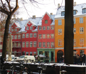 A quiet plaza in Copenhagen, Denmark, offers a scenic view of colorfully painted buildings.