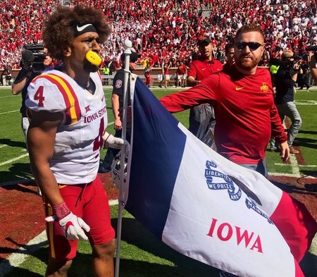 Iowa State defensive back Everett Edwards plants the Iowa state flag on Oklahomas football field after the Cyclones beat the Sooners on Saturday.